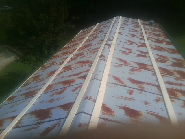 Rusted metal roof panels with new wood purlins before replacement — Storm Damage Roof Repair in Cherokee by Roofing Brothers