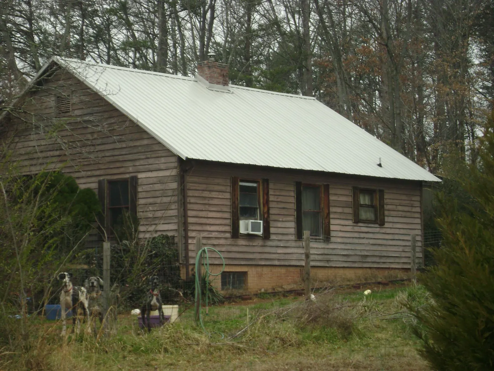 White metal roof on an old wood sided farmhouse, from a Metal Roof Installation job in Cherokee
